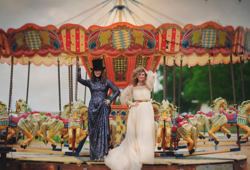 Jolie and Amie Sikes, founders of Junk Gypsy, posing in front of a vintage carousel in Round Top, Texas