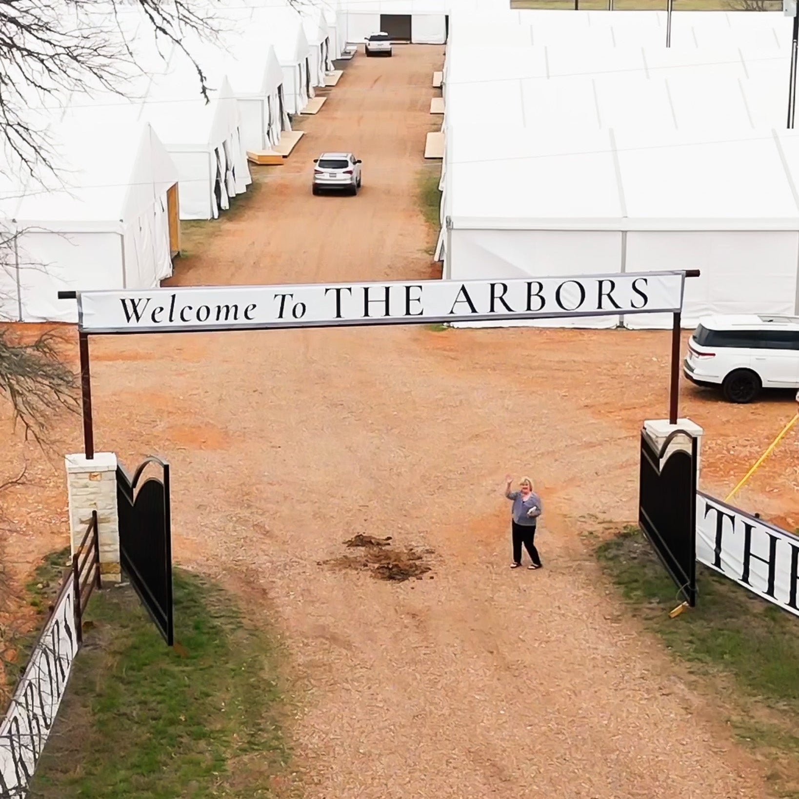 The Arbors entrance sign with white tents at the new Round Top location on Highway 237