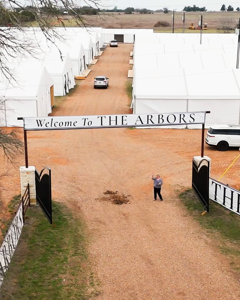 The Arbors entrance sign with white tents at the new Round Top location on Highway 237